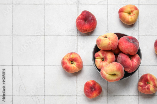 Bowl with sweet fig peaches on white tile background