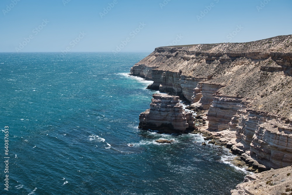 Waves hitting the Island Rock at Kalbarri National Park Coastal Cliffs. Impressive coastal cliffs in Kalbarri National Park, Western Australia. Stunning and rough coastline of Western Australia. Waves hitting the Island Rock at Kalbarri National Park Coastal Cliffs. Impressive coastal cliffs in Kalbarri National Park, Western Australia. Stunning and rough coastline of Western Australia.