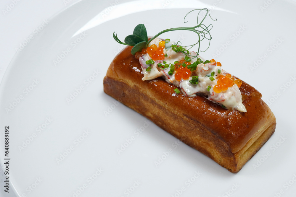 lobster roll, mixture of prawns and lobster meat with avocado in a bread roll with white background lobster roll, mixture of prawns and lobster meat with avocado in a bread roll with white background