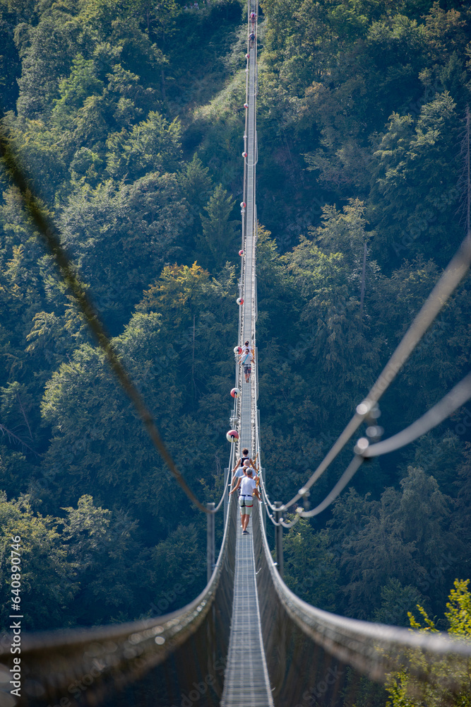 Obraz premium People while crossing the Tibetan bridge of Dossena.Which is the longest in the world