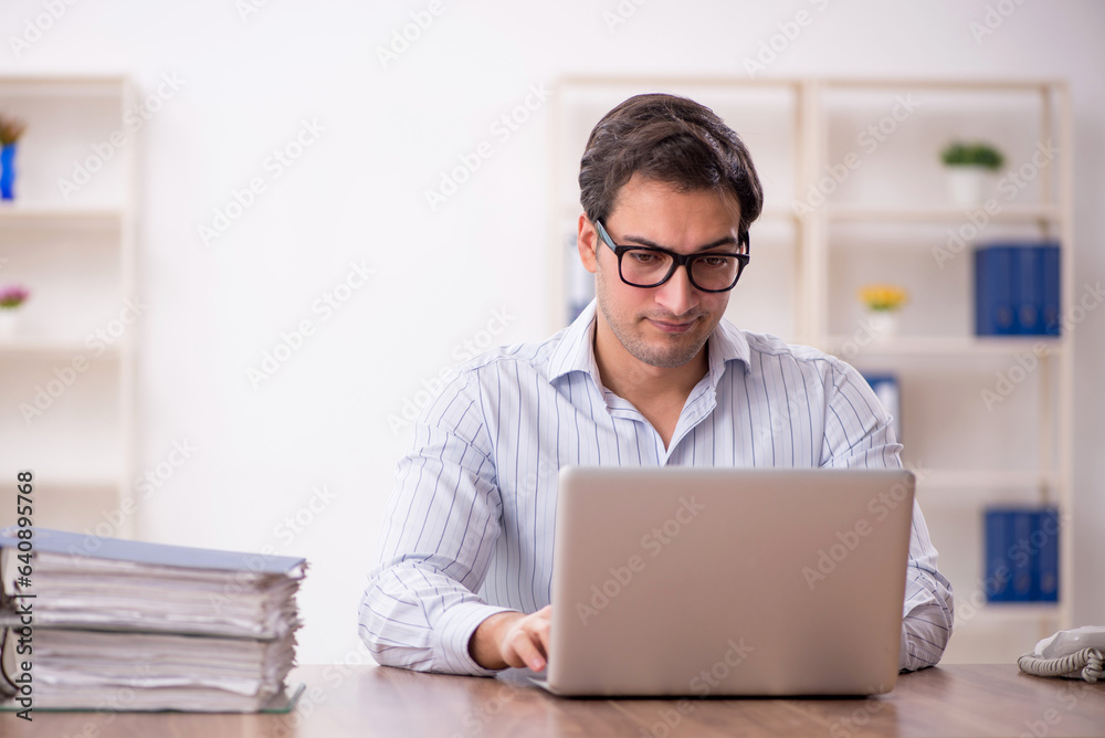 Young male employee and too much work in the office Young male employee and too much work in the office
