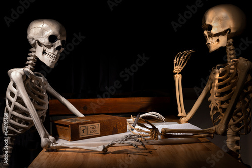 Two Halloween skeletons doing their taxes at a table
