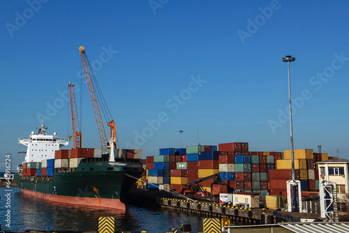Loading of containers into cargo ship in the harbor