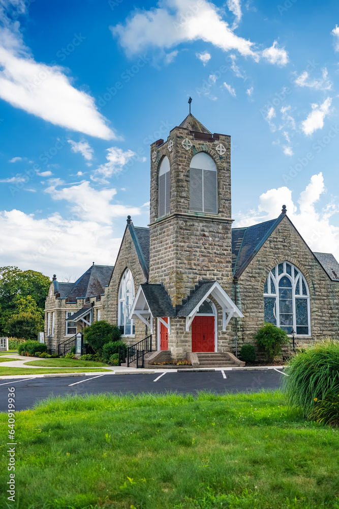 Exterior of Modern Church with red doors. Summer day, blue sky.