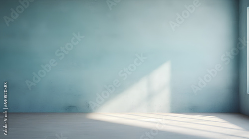 A simplistic abstract backdrop in light blue  designed for product presentations. Play of shadows and light cast by windows onto a plastered wall.
