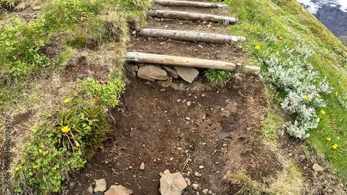 Hiker hiking in lush rainforest and wooden stair on trail in summer at Iceland photo