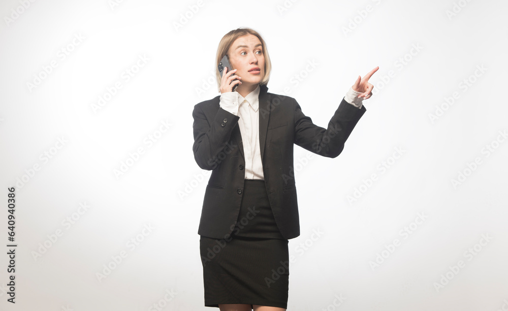 professional woman with a smartphone on a white background.girl in a black business suit with different emotions on a white background professional woman with a smartphone on a white background.girl in a black business suit with different emotions on a white background