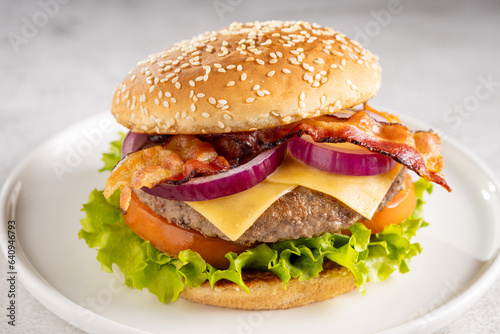 Delicious hamburger with meat, cheese, bacon and salad.