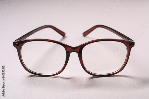 Stylish pair of glasses on light background, closeup