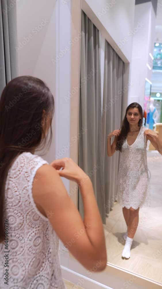 Two friends are aiding each other in trying on bathing suits in the shop. Two friends are aiding each other in trying on bathing suits in the shop.