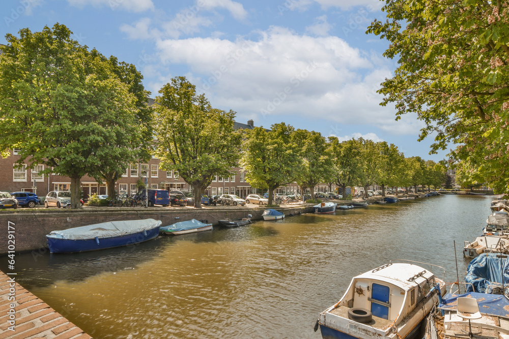 some boats docked in the water near trees and buildings on either side of the river with blue skies above them some boats docked in the water near trees and buildings on either side of the river with blue skies above them