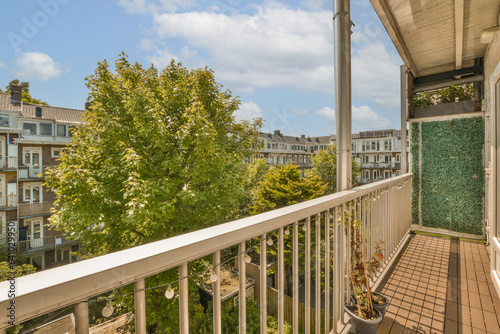 a balcony with some trees and buildings in the background on a sunny day, as seen from an apartment's balcony