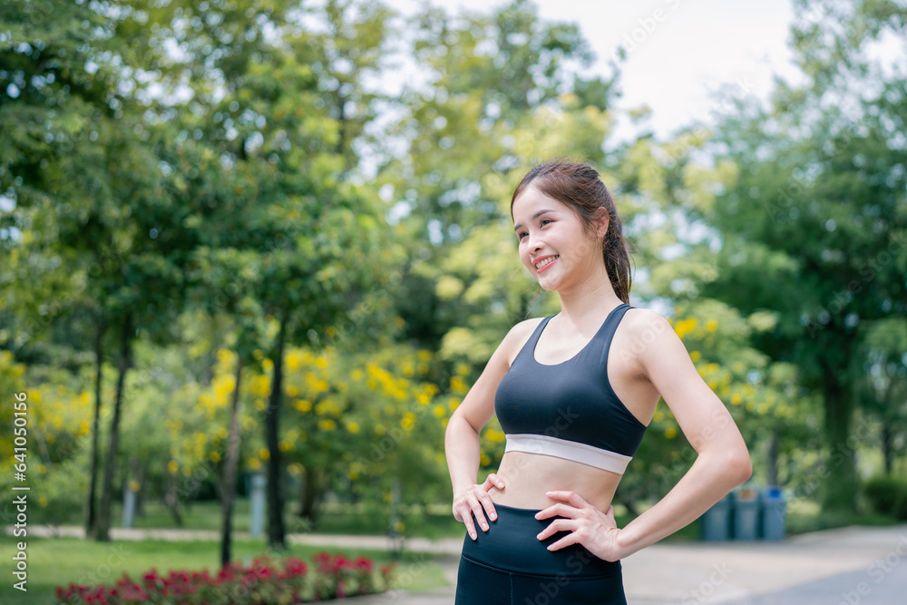 Portrait of young woman in fitness wear exercising in park. Healthy Concept, copy space.
