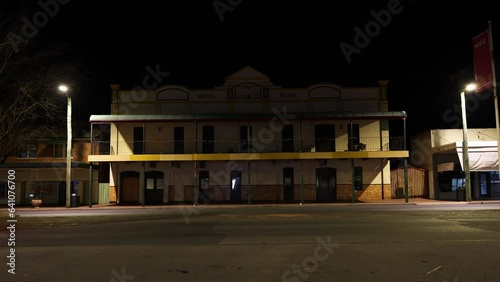 Lorry and car pass by Hotel Royal, a Victorian-style building, at night in Coonabarabran, NSW, Australia. photo