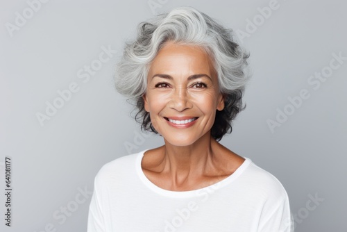 Beautiful gorgeous 50s mid age beautiful elderly senior model woman with grey hair laughing and smiling. Mature old lady close up portrait. Healthy face skin care beauty, skincare cosmetics, dental.