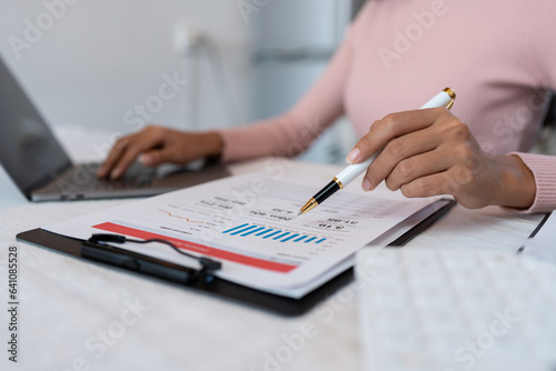 Asian business woman Calculate income with calculator, check document, financial report or profit. Income tax. Management concept. Accounting and Finance.