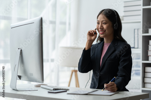 Asia call center with headset and microphone working on laptop Female entrepreneurs serving customers, business information, inquiries Support call center representatives help customers.