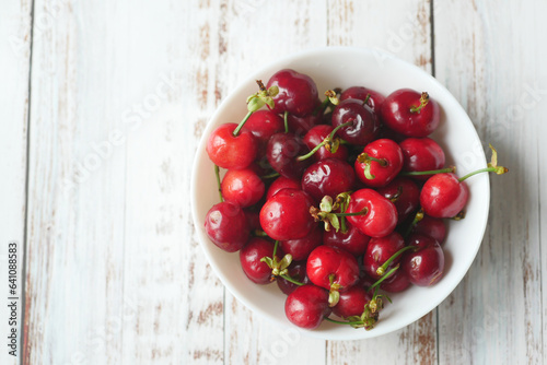Bowl of cherries on a wooden background 