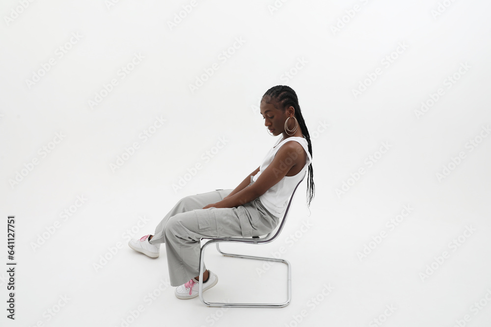 Side portrait of young woman with long braids, posing on white wall. Mock-up. Side portrait of young woman with long braids, posing on white wall. Mock-up.