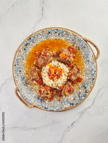 Roast beef and millet porridge on plate on wooden board