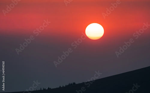 The sun sets on the mountain. Beautiful sunset in a mountainous area. © bogdan vacarciuc