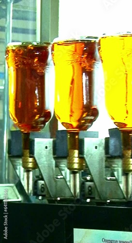 Whiskey and brandy production line. Factory machine pouring alcohol into bottles