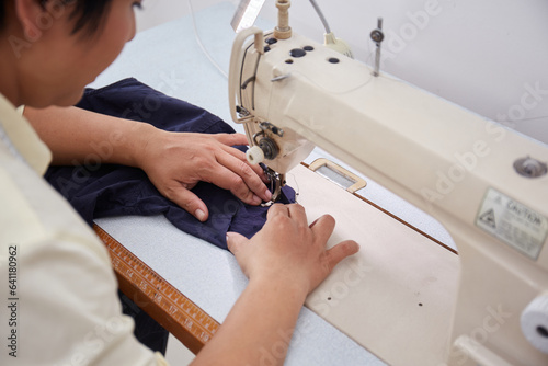 Photography Portrait of Asian Tailor working with sewing machine