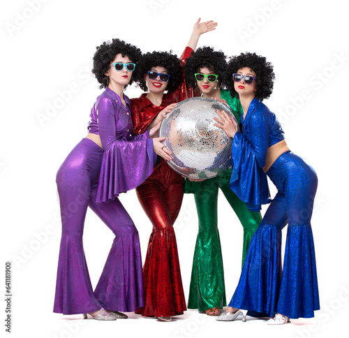 A group of girls in disco costumes are holding a disco ball and looking at the camera.