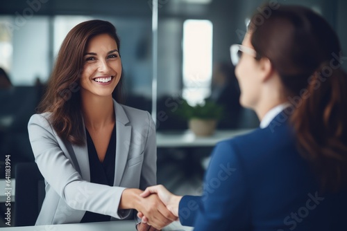 Happy mid aged business woman manager handshaking at office meeting. Smiling female HR hiring recruit at job interview, bank or insurance agent, lawyer making contract deal with client at work.