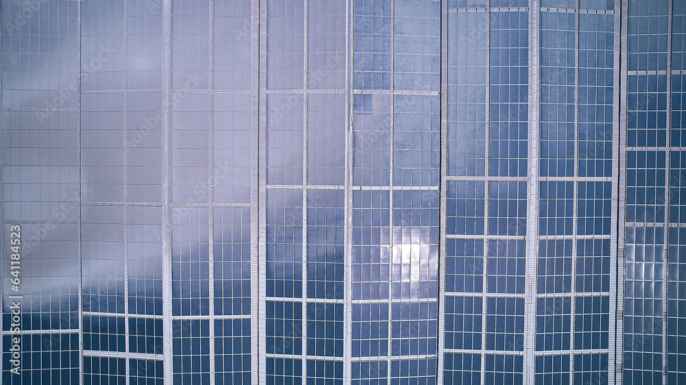 Top down aerial view of industrial building with photovoltaic panels installed on roof. Solar panel on industrial building roof. Solar PV panels aerial view