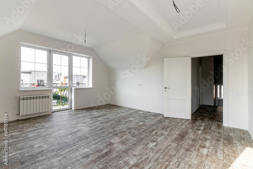 A room in a private house immediately after laying the floor, white unfinished walls and ceiling © Dzmitry Halavach