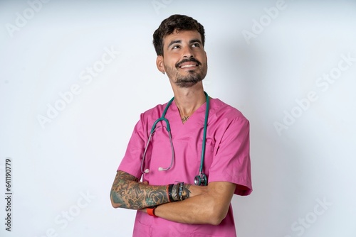 Bild auf Leinwand young caucasian doctor man wearing pink medical uniform makes bunny paws and loo