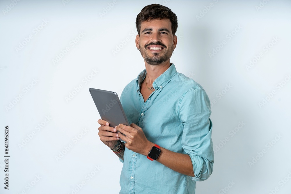 Photo of optimistic young caucasian man wearing green shirt hold tablet Photo of optimistic young caucasian man wearing green shirt hold tablet