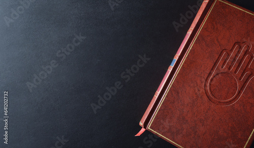 Background with sacred book with engraved jain symbol top view