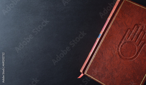 Background with sacred book with engraved jain symbol top view photo