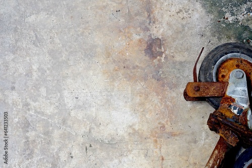 A old rusty wheelbarrow on cement floor background with copy space.