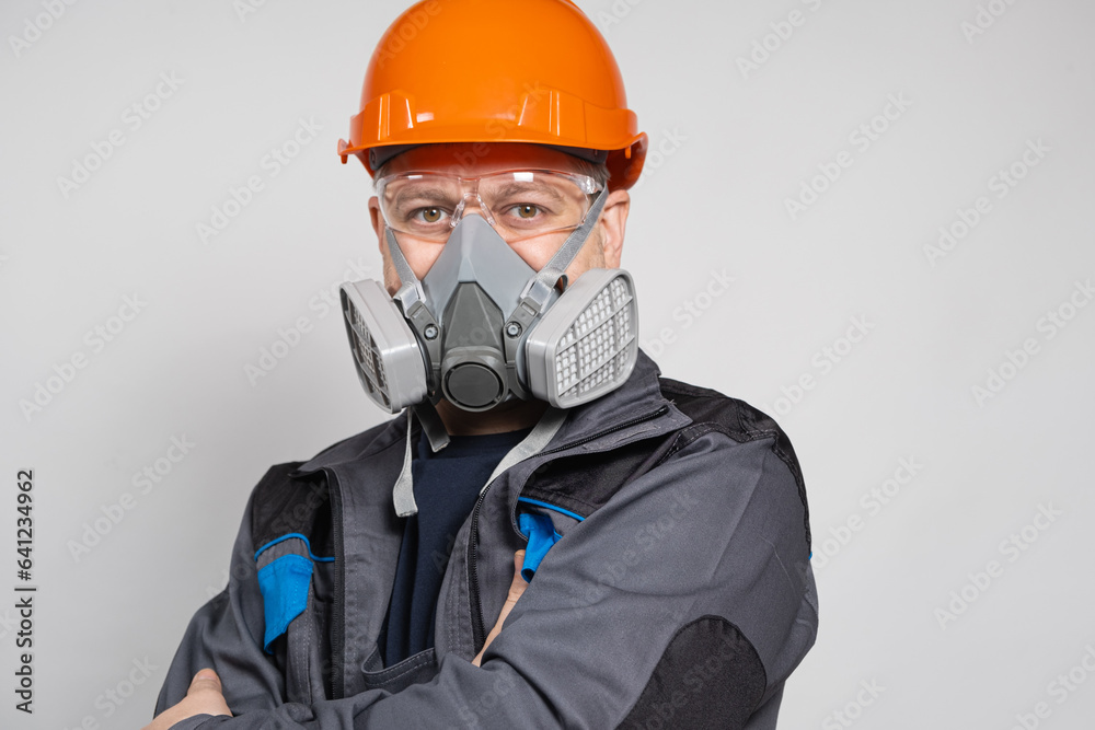 A man wearing a helmet, respirator and goggles on a white background