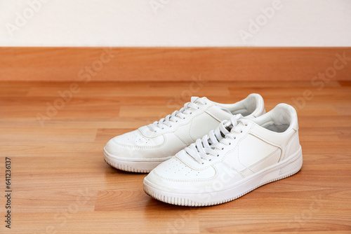 White sneakers on wood laminate flooring