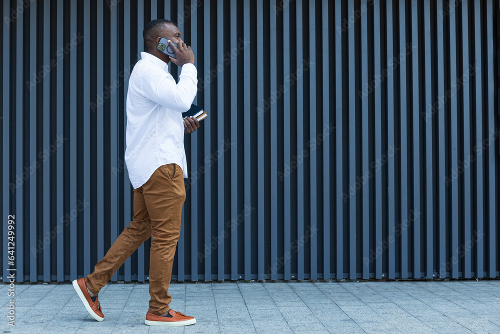 A young, successful African-American man with a notebook and a smartphone in his hands