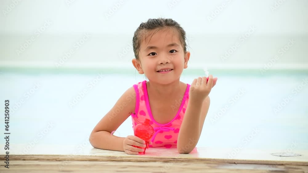 Adorable happy cute girl playful foam bubbles in swimming pool in summer outdoors. Funny Cheerful girl have fun happiness times. Bubbles blowing soap playful in pool. Joyful child playful happy Adorable happy cute girl playful foam bubbles in swimming pool in summer outdoors. Funny Cheerful girl have fun happiness times. Bubbles blowing soap playful in pool. Joyful child playful happy