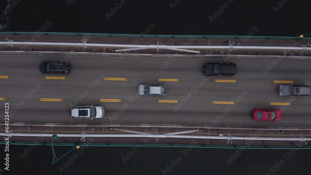 Bird view of a road in Vancouver over a bridge with a passenger vessel crossing below Bird view of a road in Vancouver over a bridge with a passenger vessel crossing below