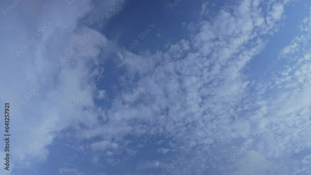 Small and large white clouds of various shapes floating across blue sky with speed of wind. Super rest for eyes with soothing colors Small and large white clouds of various shapes floating across blue sky with speed of wind. Super rest for eyes with soothing colors