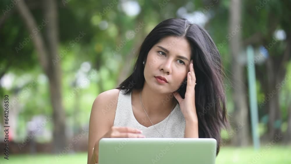 Recession Stress Woman using laptop work hard at home office outdoor in green park. Young women have headache, depressed from failure business burnout. Tired Asian woman despair sadness problems Recession Stress Woman using laptop work hard at home office outdoor in green park. Young women have headache, depressed from failure business burnout. Tired Asian woman despair sadness problems