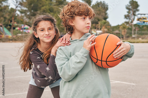 Carefree teenagers with basketball on street