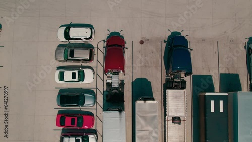epic top down aerial of a red semi bobtail backing up to a reefer - dry van trailer to hook it up. Proccess of coupling a tractor and trailer. Parking yard with other tractors and trailers parked. USA