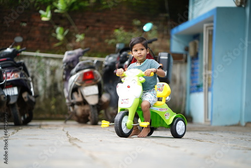 cute indian kid, indian boy enjoy cycle riding, Little Indian kid playing in a house stock images 
