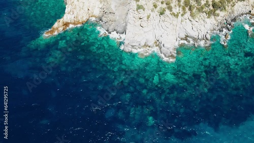 A drone takes off over the crystal clear sea on the island of Sardinia in Italy