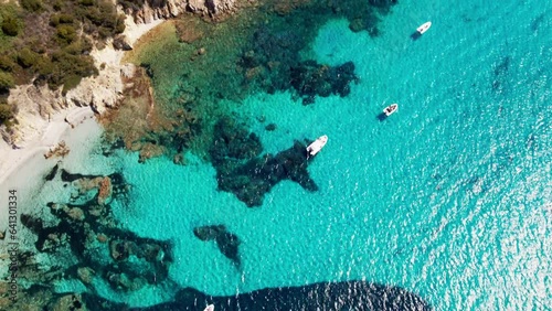 Top view of small boats near the shore with perfectly clear water on the island of Sardinia Italy.