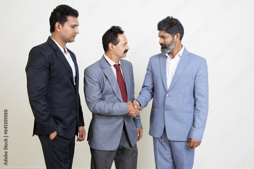 Group of positive indian business people wearing suit shaking hands isolated on white studio background. Corporate Concept. Group of positive indian business people wearing suit shaking hands isolated on white studio background. Corporate Concept.
