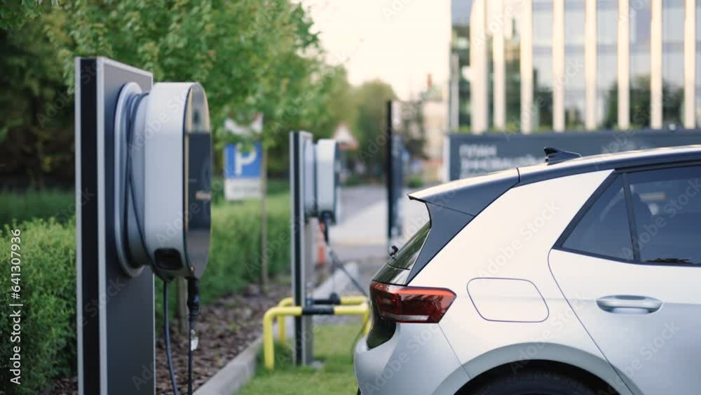 Charge station for electric cars. Electric car charger. Alternative energy for ecological cars. Electric, zero pollution cars on green energy concept on modern city parking lot